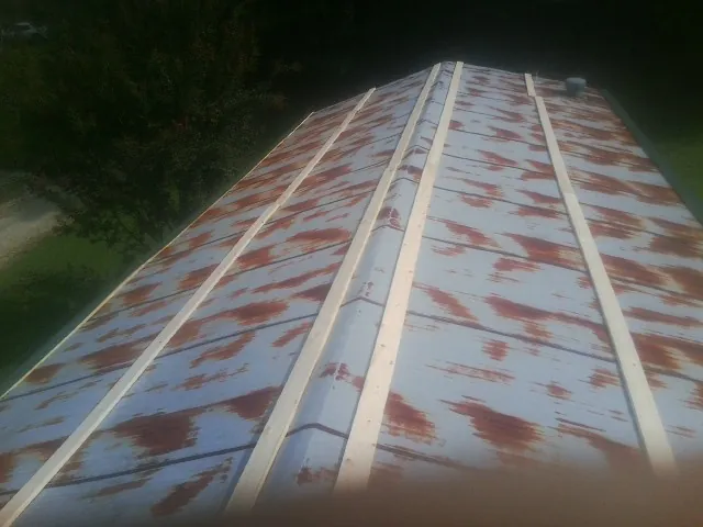 Rusted metal roof panels with new wood purlins before replacement — Storm Damage Roof Repair in Linthicum Heights by Roofing Brothers